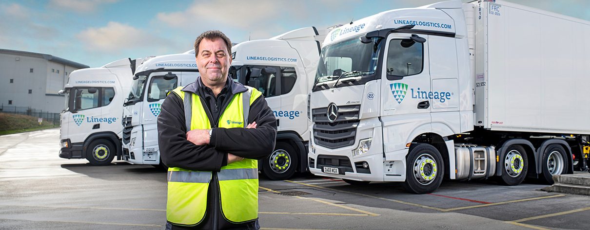 Driver standing in front of 4 Lineage trucks